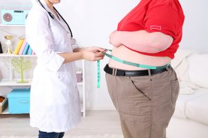 Doctor examining patient obesity on light background