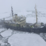 Research vessel named Malho navigating through ice-covered waters with crew members on board.
