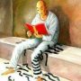 A man in prison attire sitting on a bench, reading a red book with a chain and ball on the floor.